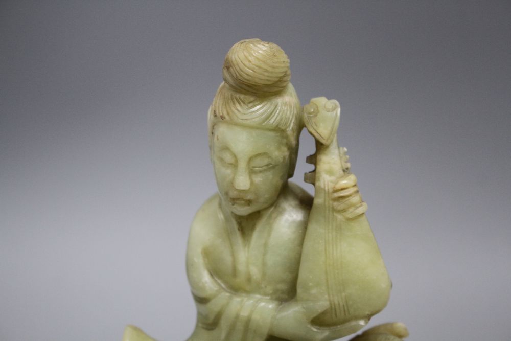 A pair of Chinese bowenite jade groups of a lady riding a horse, wood stands total height 26.5 and 27cm